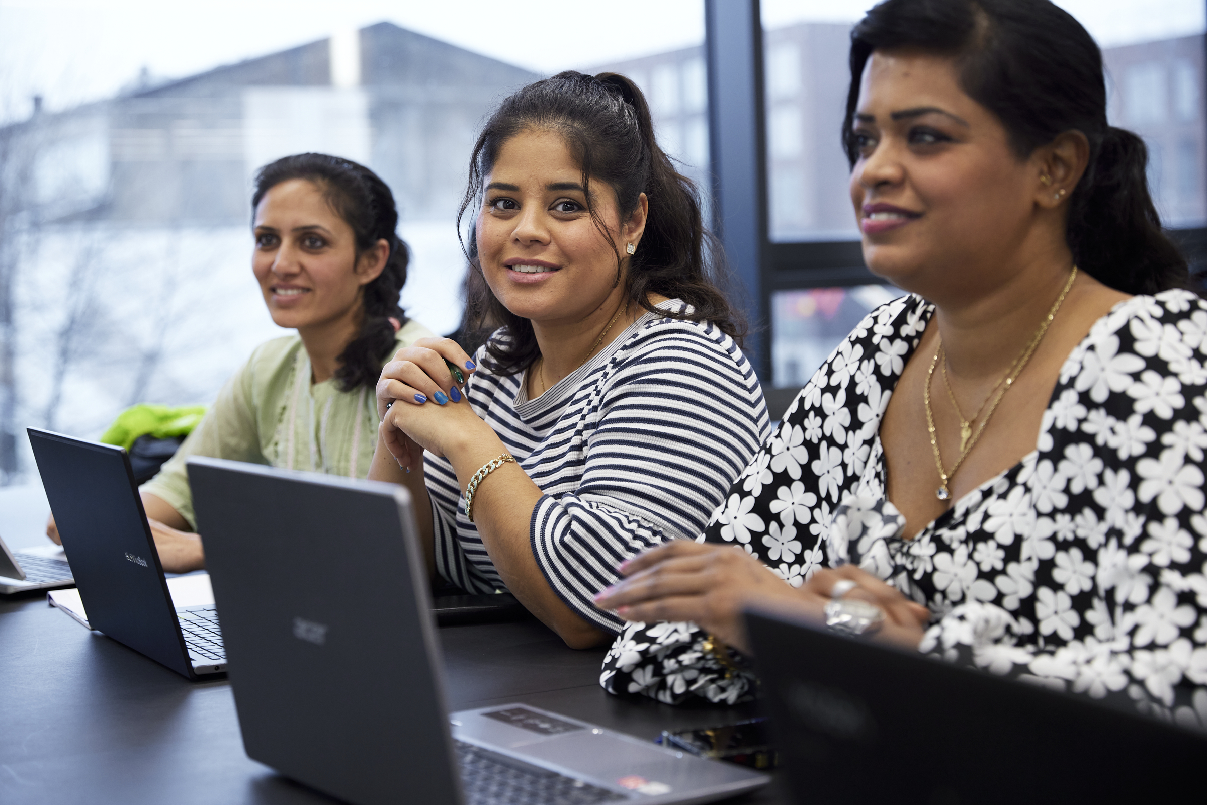 Tre kvinder der sidder med computere foran sig
