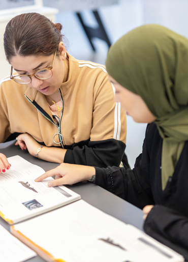 To kvinder laver skoleopgaver sammen.